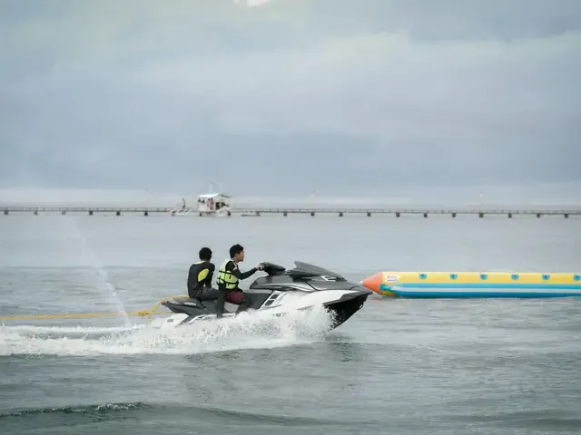 Un bateau tracte une bouée chargée de participants en gilet