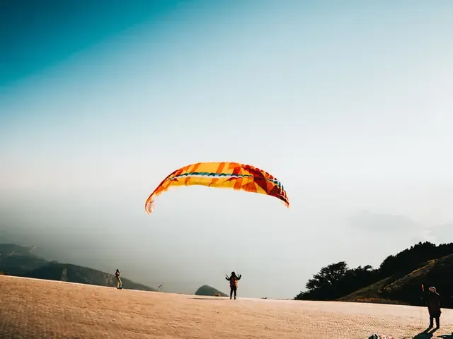 Une voile de parapente en vol au-dessus d'un relief